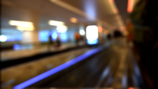 Motion-blurred-point-of-view-pov-of-passenger-walking-on-moving-walkway-in-modern-airport-terminal