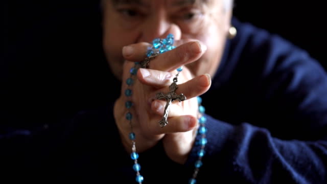 close-up-on-Hands-of-desperate-old-woman-praying-with-the-rosary