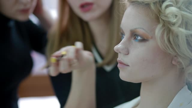 Artista-de-maquillaje-explicar-al-alumno-cómo-usar-cosméticos