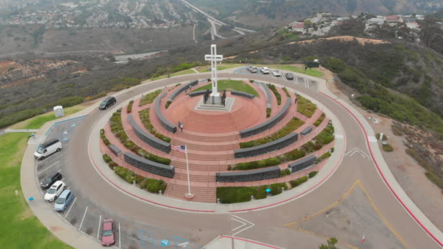 Beautiful-Aerial-Shot-Circling-Mt.-Soledad-with-the-Cross,-Cars,-Trees,-Grass,-Hills,-Homes-and-Coast-in-View-in-San-Diego,-California