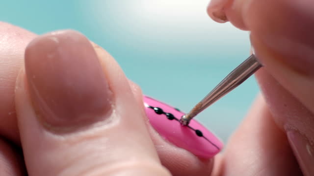 Extreme-Close-up,-Manicure-Master-Decorates-Girl's-Nail,-Puts-on-Pink-Lacquer-Brilliant-Dots