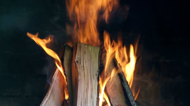 Holz-Feuer-in-einem-Kamin-aus-rotem-Backstein