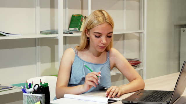 Attraktive-Studentin-ihre-Hausaufgaben-mit-laptop