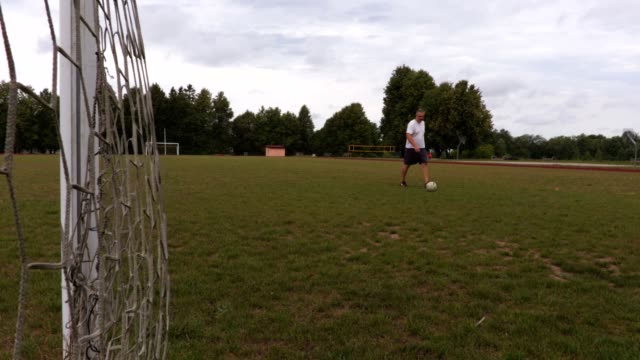 Fußball-Spieler-jongliert-einen-Ball-vor-dem-Tor
