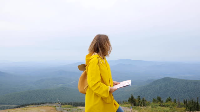 Joven-excursionista-mujer-mirando-el-mapa-de-la-montaña
