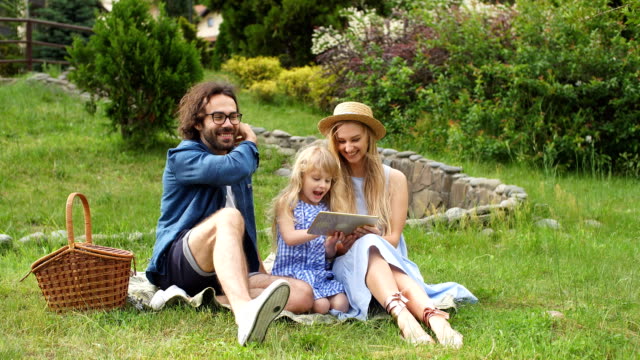 Familie-mit-digital-Tablette-während-Picknick-am-Land