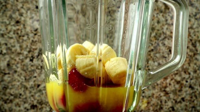 Vorbereitung-der-cocktail-in-den-Mixer-aus-Erdbeeren,-Bananen-und-Orangen-Saft-Slow-Motion.