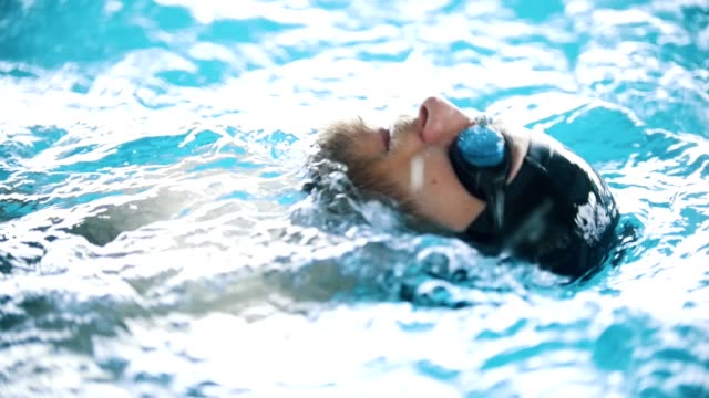 Disabled-man-swims-on-the-back-in-a-swimming-pool.-Close-up-shot.-Slow-motion