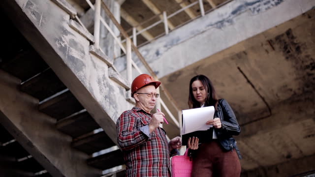 Woman-engineer-talking-to-a-foreman-on-the-construction-site,-solving-organizational-issues.