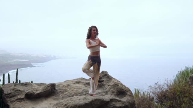 Young-woman-meditate-on-the-top-of-mountain