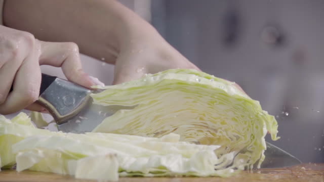 Cutting-cabbage-with-knife-on-the-wood.-Slow-motion