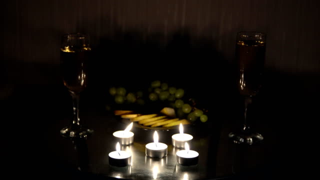 Noche-romántica-con-velas-con-champagne-y-frutas