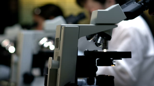 Students-in-a-chemistry-lab-look-through-a-microscope-during-their-experiments