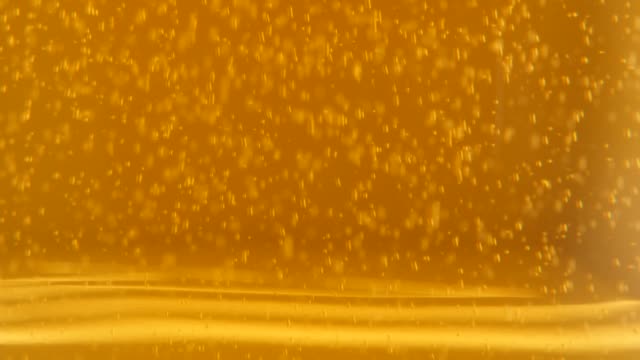Slow-tilting-on-glass-full-of-beer-bubbles-and-foam-4K-2160p-UltraHD-footage---Golden-full-color-of-fresh-beer-bubbles-4K-3840X2160-UHd-video