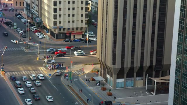 High-aerial-time-lapse-view-of-cars-on-a-traffic-light-and-crowds-of-people-crossing-a-street-in-the-city