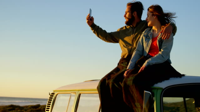 Couple-taking-selfie-during-sunset-on-beach-4k