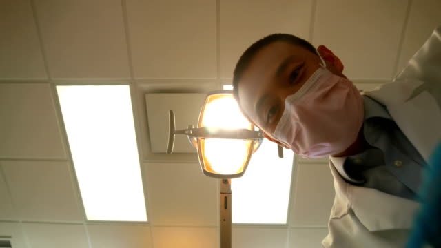 Male-dentist-examining-a-patient-with-tools-4k