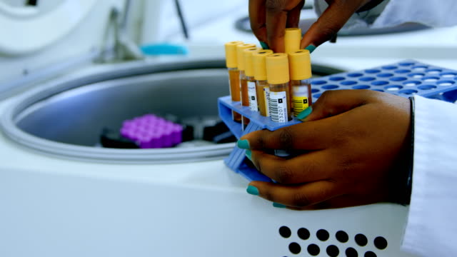 Laboratory-technician-taking-out-blood-plasma-samples-from-centrifuge-4k