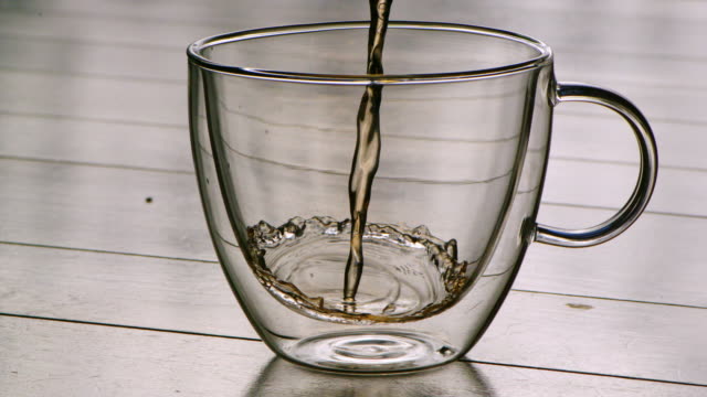Pouring-hot-tea-into-a-glass-in-slowmotion