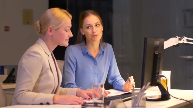 businesswomen-with-computer-working-late-at-office