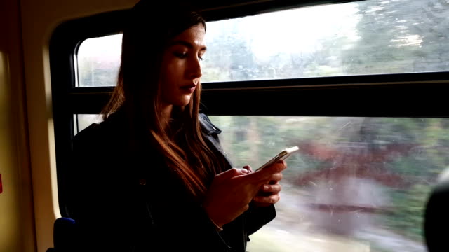 Mujer-en-el-tren-con-el-teléfono-inteligente