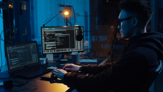 asian-hacker-in-dark-room-with-computers-at-night
