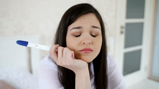Sad-woman-with-pregnancy-test-at-home