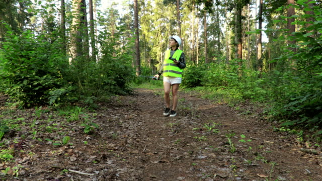 Woman-Worker-starting-forest-inspection-with-Drone-on-forest-path