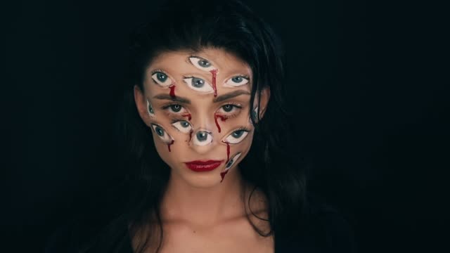 Kunst-Halloween-Make-up,-Frau-hat-viele-Augen-auf-ein-Gesicht
