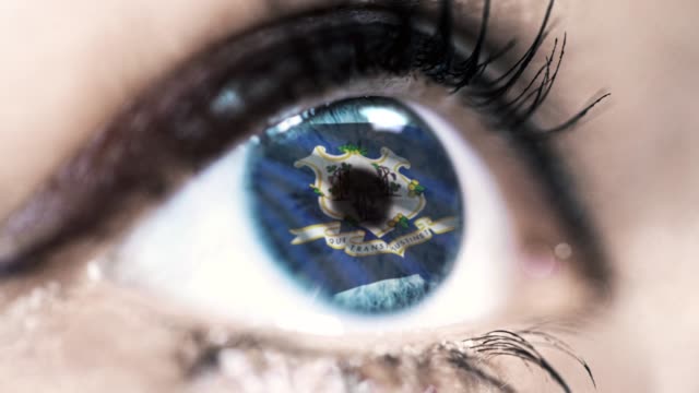 Mujer-ojo-azul-en-primer-plano-con-la-bandera-del-estado-de-Connecticut-en-iris,-estados-unidos-de-América-con-movimiento-de-viento.-concepto-de-vídeo