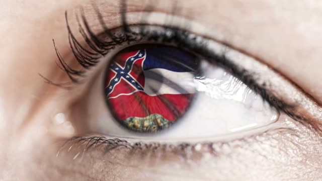 Woman-green-eye-in-close-up-with-the-flag-of-Mississippi-state-in-iris,-united-states-of-america-with-wind-motion.-video-concept