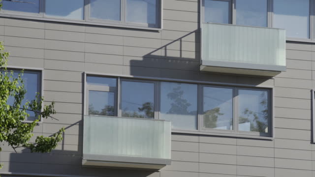 Foto-de-cerca-del-edificio-residencial.-Piso-exterior-con-reflejo-en-ventanas.-El-edificio-cuenta-con-exterior-con-pequeños-balcones