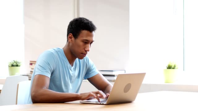 Traurigen-schwarzen-Mann-verärgert-durch-Verlust,-am-Laptop-arbeiten