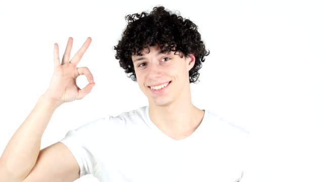 Okay-Sign-by-Young-Man-with-Curly-Hairs,-white-Background