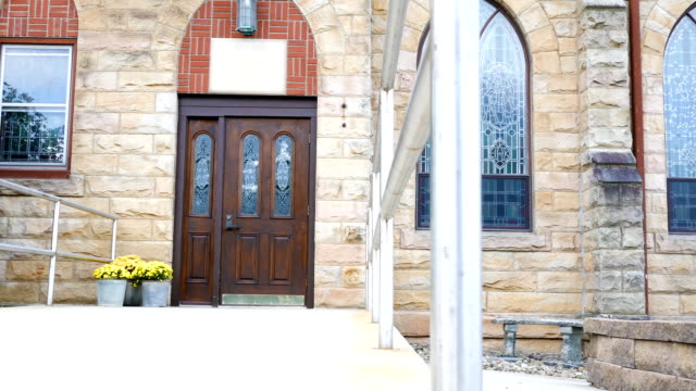 Camera-pans-across-the-entrance-of-a-church-or-chapel-exterior-in-summer
