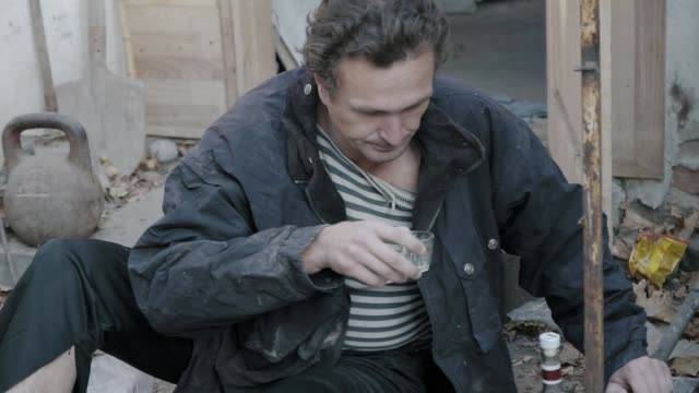 Eine-Obdachlose-Alkoholiker-trinkt-Wodka-auf-der-Müllkippe-(full-HD)