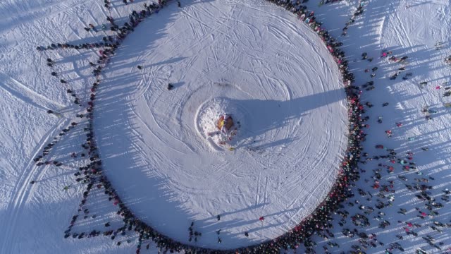 Circle-of-people-which-watch-burning-of-dummy-during-celebration-of-Russian-traditional-holiday-Maslenitsa.-Footage.-Aerial-view