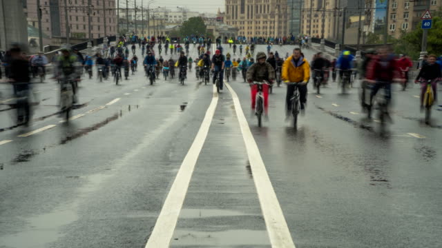parade-of-bicyclists,-bike-riders--despite-the-bad-weather,-time-lapse