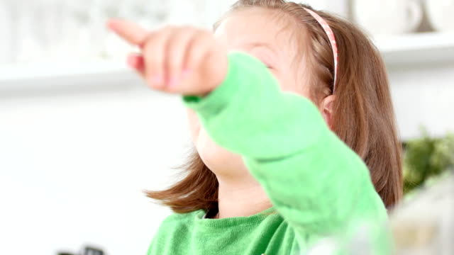 Bebé-niña-ríe-señalando-dedo-y-divirtiéndose-en-el-estudio