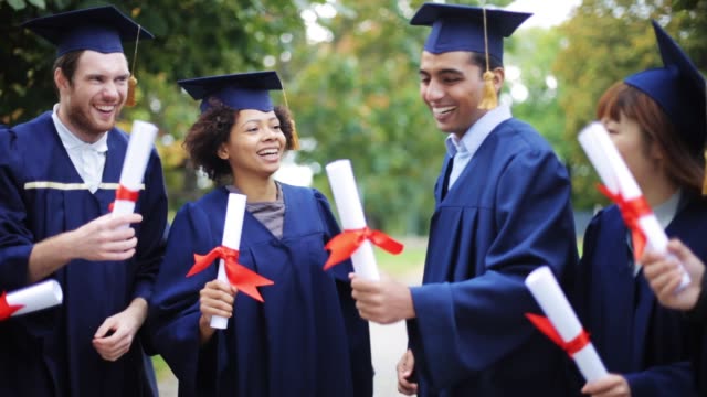 happy-students-in-mortar-boards-with-diplomas