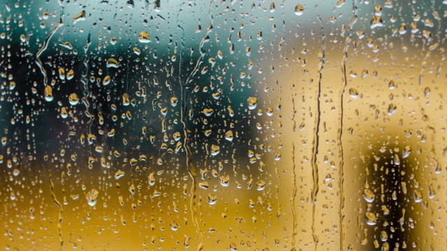 Zeit-Regentropfen-Ablauf-auf-das-Fensterglas.-Nahes-hohes-Wasser-Textur