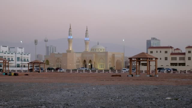 view-on-small-arabian-mosque-in-a-city-in-dusk,-silhouette-of-beautiful-mountain-is-in-background