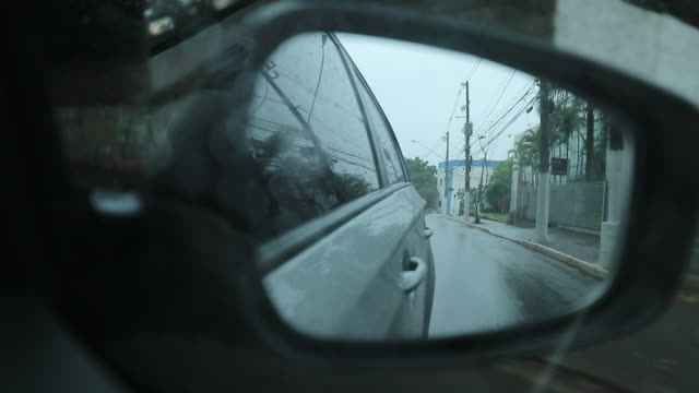 Car-side-view-mirror-during-rainy-day