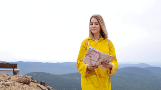 Joven-excursionista-mujer-mirando-el-mapa-de-la-montaña