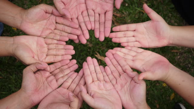 Hand-geben-ein-rotes-Herz,-viele-Hände-der-Menschen