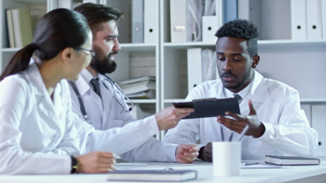 Diverse-Colleagues-in-Lab-Coats-at-Meeting