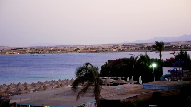 Ägyptischen-Resort.-Einer-der-vielen-ruhigen-Buchten-des-Roten-Meeres,-bei-Sonnenuntergang,-in-der-Dämmerung.-vor-dem-Hintergrund-die-Umrisse-von-Gebäuden,-Palmen,-Berge
