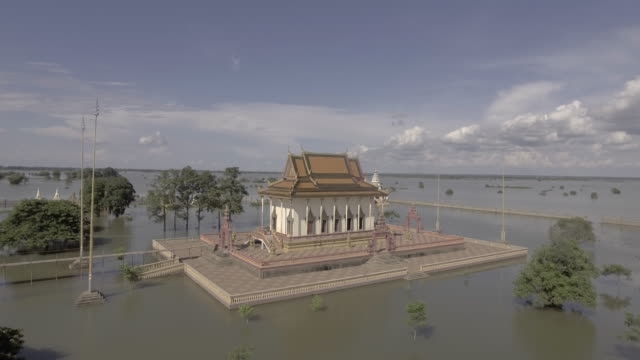 Aerial-static-view-of-a-pagoda-is-surrounded-by-floodwaters-under-cloudy-skies