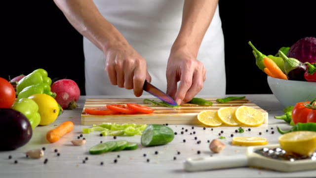 Chef-is-cutting-vegetables-in-the-kitchen,-slicing-sweet-green-bell-pepper