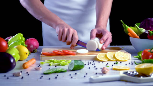 Chef-is-cutting-black-turnip-in-the-kitchen,-slicing-black-radish
